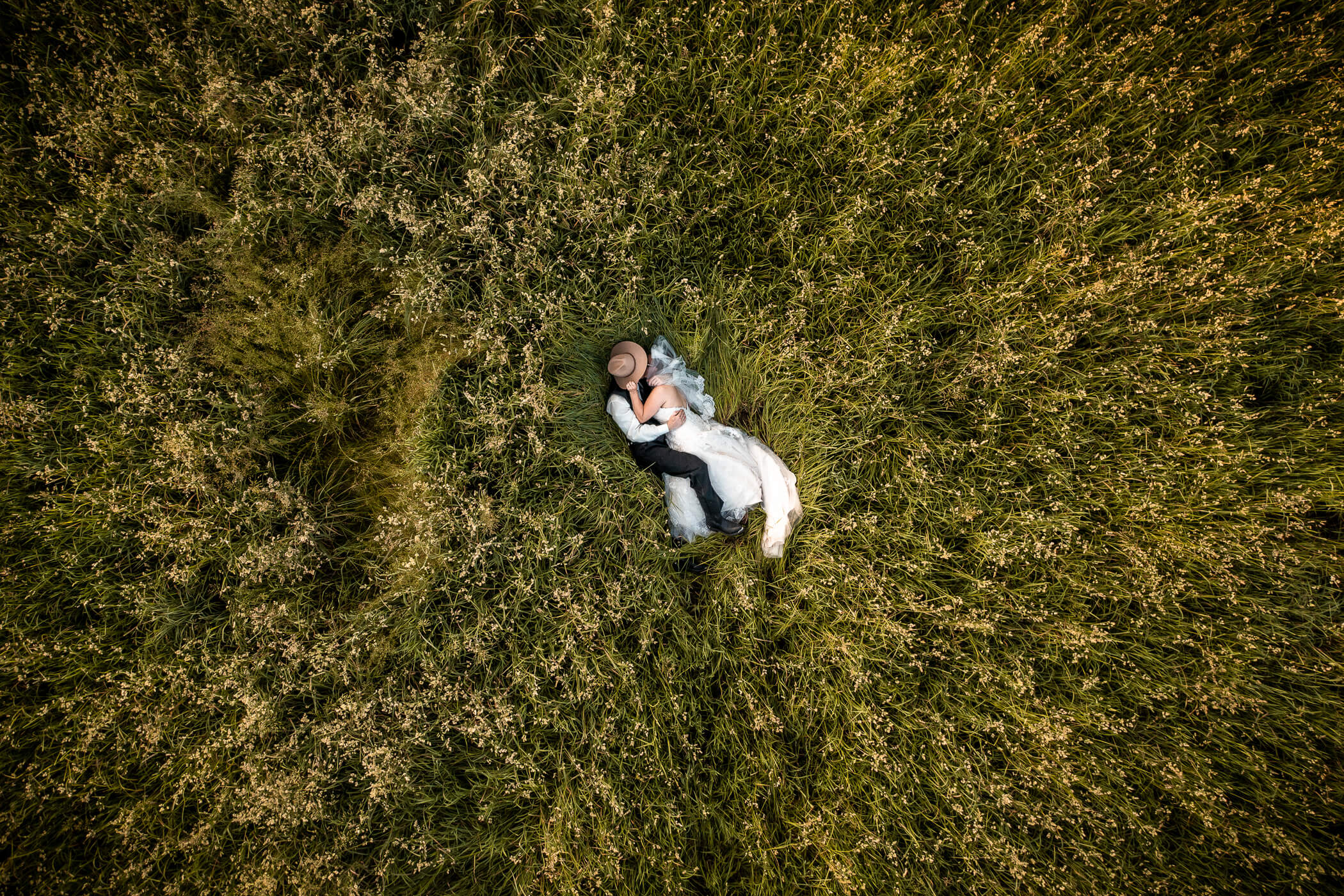 Drone Shot of a couple lying together in a grass field at a garden wedding venue in Pittsburgh PA